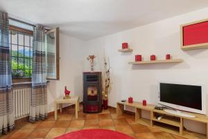 a living room with a television and a fireplace at La Casa Di Pasky in Roisan