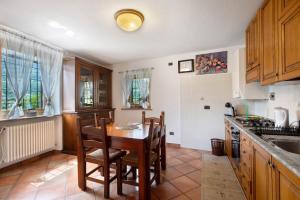 a kitchen with a table and chairs and a sink at La Casa Di Pasky in Roisan