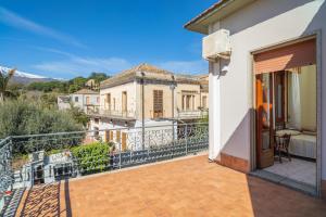 a balcony with a view of a house at Il Comandante in Piedimonte Etneo