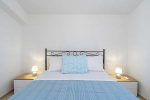 a bedroom with a blue bed with two lamps at Littiricci in Marzamemi