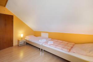 two beds in a room with a yellow wall at Urlaub Ostholstein in Stockelsdorf