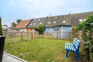 a blue bench in a yard next to a fence at Kranich in Pruchten