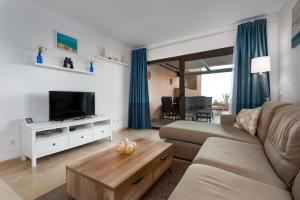 a living room with a couch and a tv at Apartment Coto Real in Manilva