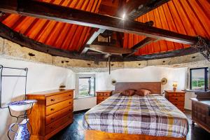 a bedroom with a bed and a wooden ceiling at Moinho das Esteveiras in A dos Cunhados