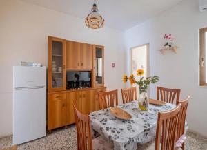 a kitchen with a table and a white refrigerator at Sabbia e Sorrisi Sea View in Porto Cesareo