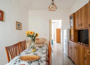 a dining room table with a vase of flowers on it at Sabbia e Sorrisi Sea View in Porto Cesareo