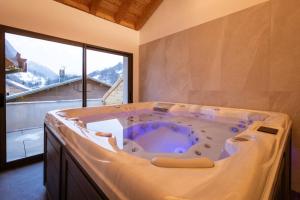 a jacuzzi tub in a room with a large window at Chalet-Spa Le Cervin in Valloire +37 photos