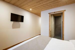 a bedroom with a bed and a tv on the wall at Chalet-Spa Le Cervin in Valloire