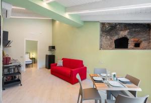 a living room with a red chair and a table at Dimora Storica Lucia in Ascea
