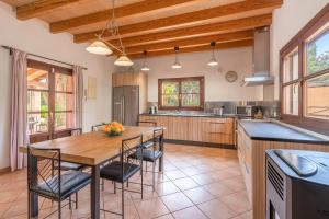 a kitchen with a wooden table and chairs at Es Vinyo in Biniali