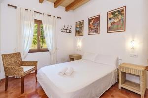 a bedroom with a bed and a chair and a window at Es Vinyo in Biniali +22 photos