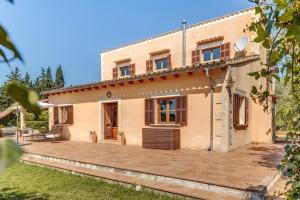 a house with a large patio in front of it at Es Vinyo in Biniali