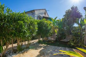 a garden with trees and benches in front of a house at Studio Bormes in Bormes-les-Mimosas