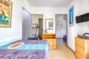 a bedroom with a bed and a tv at Chalet dans résidence piétonne in Hourtin