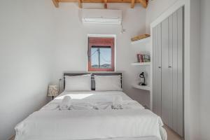 a white bedroom with a large bed with white sheets at Angel’s studio in Potamós