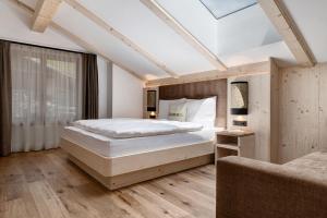 a bedroom with a large bed with a skylight at Daunëihof in Selva di Val Gardena