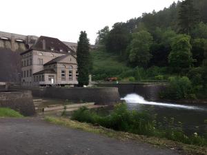 a river in front of a building with a waterfall at Am Trapp in Padberg +9 photos