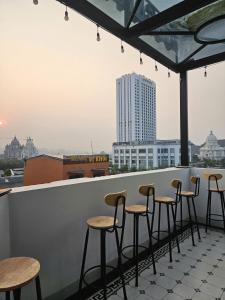 a row of stools on a rooftop bar with a view at OCEAN HOTEL Ninh Binh - Near Trang An & Hoa Lư Old Town in Kỳ Vĩ