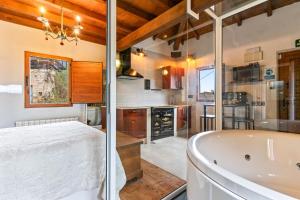 a luxurious bathroom with a tub and a kitchen at La Manzana in Candamin