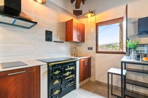 a kitchen with a stove and a sink and a window at La Manzana in Candamin +6 photos