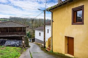 a yellow building with a street next to a house at La Manzana in Candamin