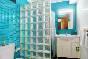 a bathroom with blue walls and a toilet and a sink at The Wave House - Seaside Haven in Jardim do Mar +17 photos