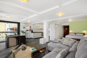 a living room with a couch and a bed at The Wave House - Seaside Haven in Jardim do Mar