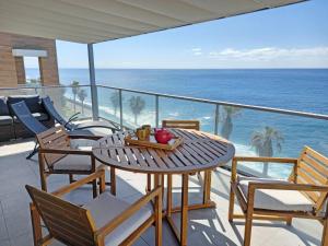 a table and chairs on a balcony with the ocean at The Wave House - Seaside Haven in Jardim do Mar