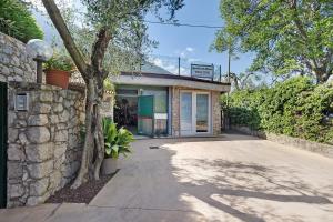 a building with a stone wall next to a driveway at Appartamento Assenza 9 in Brenzone sul Garda