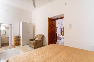 a bedroom with a bed and a chair at Elena Inn in Matino