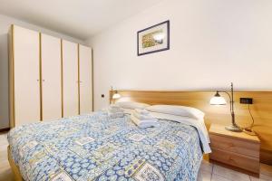 a bedroom with a bed with a blue and white quilt at Appartamento Assenza 9 in Brenzone sul Garda +17 photos