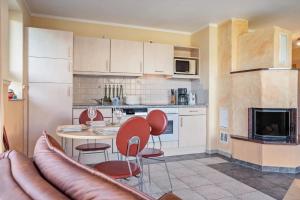 a kitchen with a table and chairs and a couch at Habichtssicht in Buschvitz