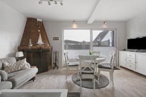 a kitchen and living room with a table and a tv at Ferienhaus Pfanne in Hennstedt