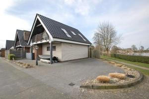 a house with a gambrel roof on a driveway at Ferienhaus Pfanne in Hennstedt