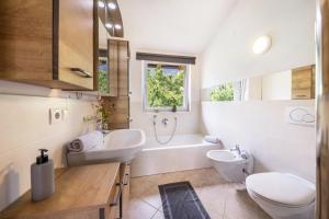 a bathroom with a sink and a toilet and a tub at Angerblick Apartment in Appiano sulla Strada del Vino +17 photos