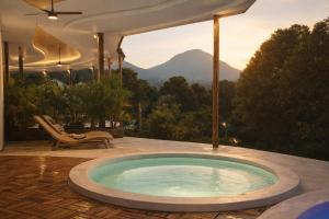 a hot tub in a patio with a view of a mountain at Bali Barn Village in Munduk