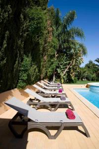 een rij ligstoelen naast een zwembad bij Hotel Parque das Laranjeiras in Vilamoura