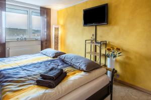 a bedroom with a bed with two pillows and a flat screen tv at Schwarzwaldblick in Sankt Georgen im Schwarzwald