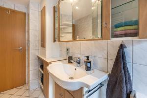 a bathroom with a sink and a mirror at Schwarzwaldblick in Sankt Georgen im Schwarzwald +19 photos