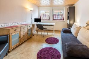 a living room with a couch and a desk at Schwarzwaldblick in Sankt Georgen im Schwarzwald