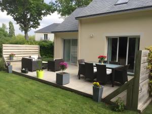 a wooden deck with a table and chairs on a yard at Chambres d'Hôtes - Les Boubous in Saint-Nazaire