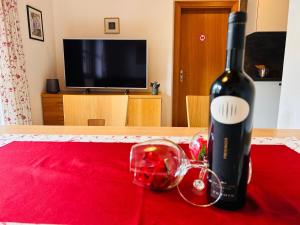 a bottle of wine and a glass on a table at App Sonnenschein - Duregger in Campo Tures