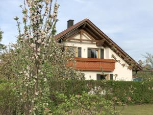 a white house with a tree in front of it at Ferienwohnung Immenberg in Dirlewang