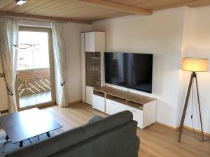 a living room with a couch and a flat screen tv at Ferienwohnung Immenberg in Dirlewang