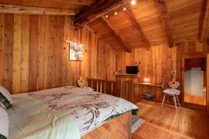 a bedroom with a bed in a wooden room at La casa di Alice in Gignod