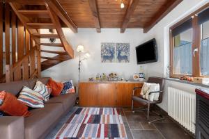a living room with a couch and a tv at La casa di Alice in Gignod