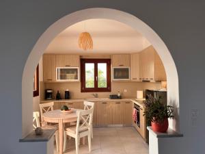 an arched kitchen with a table and a dining room at Beach front Villa Pasithea in Monolithos