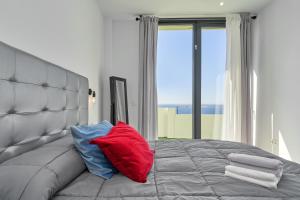 a bed with a red and blue pillows on it at Villa Joya del Mediterraneo in Almuñécar +36 photos