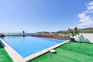 a swimming pool with a view of the ocean on a building at Villa Joya del Mediterraneo in Almuñécar