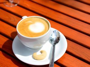 a cup of coffee and a cookie on a plate at Winzercafé Neipperg in Brackenheim